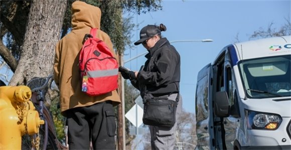 City of Modesto CHAT Team Member talks to ta member of the public on a street corner. 