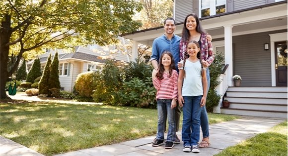 Photo of family standing in front of house.