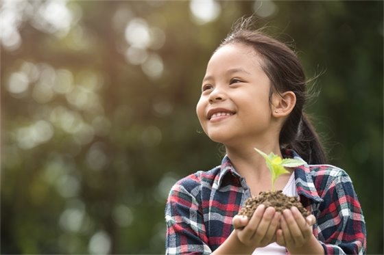 Child holding new tree.