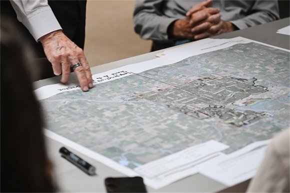 Fingers pointing to a printed map of the of the City of Modesto on a table. 