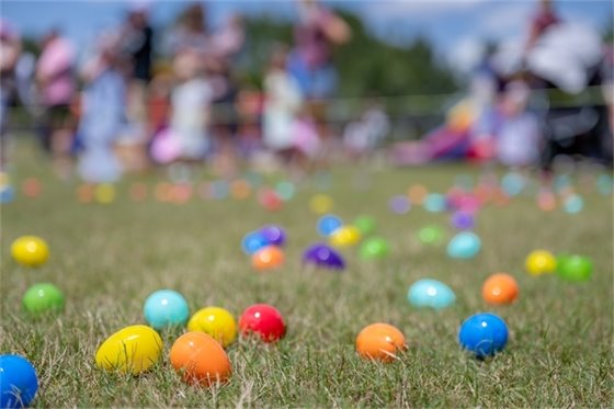 Easter eggs spread out on a green grass field.
